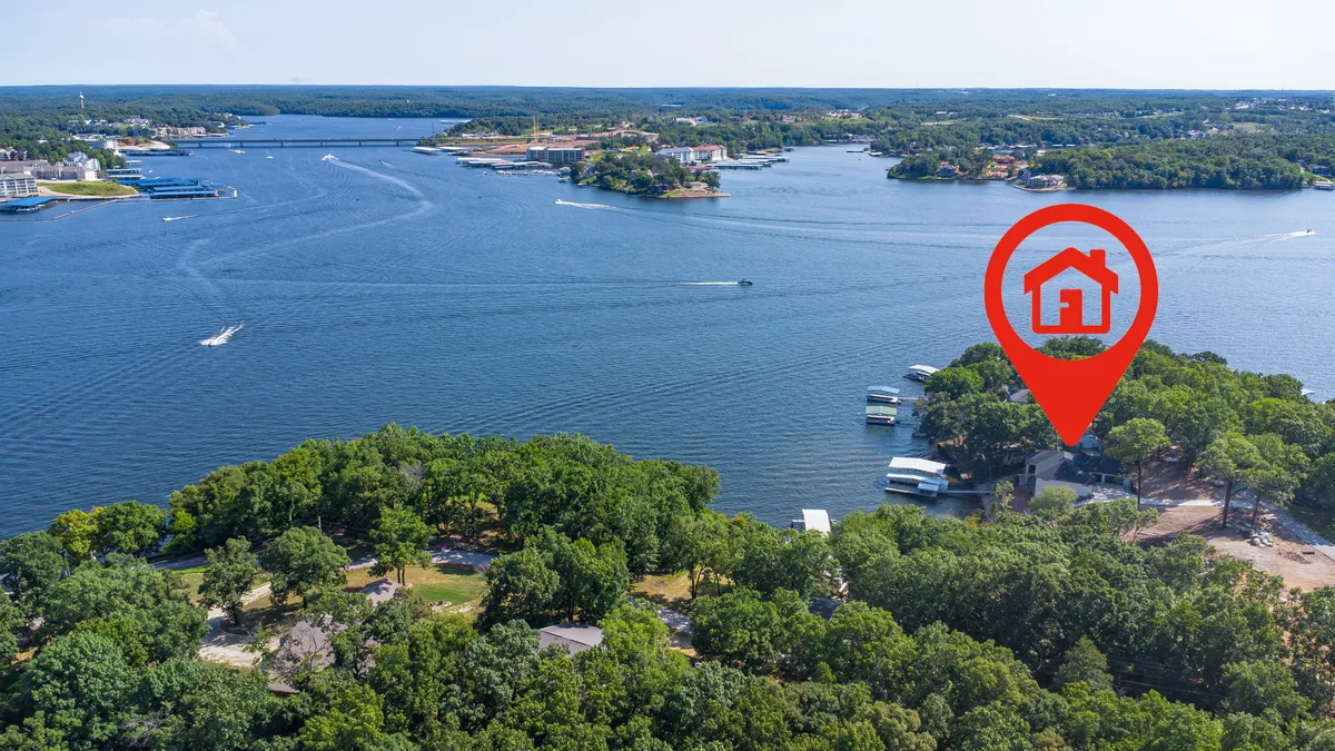 A scenic wide-angle shot of the lake portrays calm waters bordered by lush greenery, with boats and neighboring houses visible in the distance. The setting is relaxed and inviting, alluding to the variety of water-based and outdoor activities available to guests, such as boating, fishing, or group picnics.