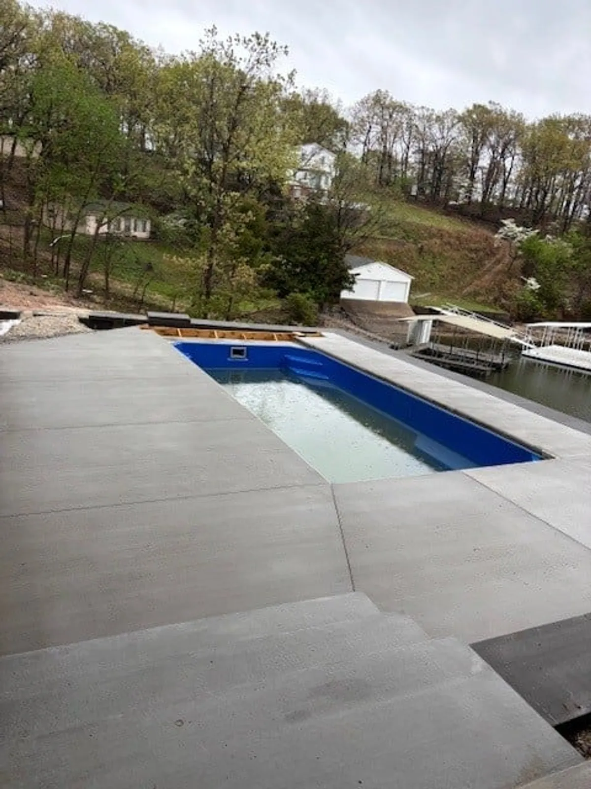 A sparkling swimming pool is the centerpiece of the patio area, surrounded by natural landscaping and ample space for sunbathing or outdoor gatherings. The setup is inviting for both energetic play and peaceful poolside lounging, enhancing the resort-like atmosphere.